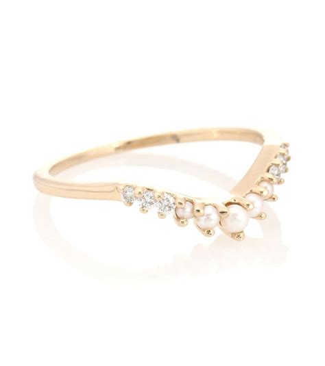 A Gold Ring With Pearls And Diamonds On The Side In Front Of A White