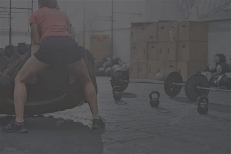 Rear View Of Woman Flipping Tire In Crossfit Gym Multiforme Le Gym