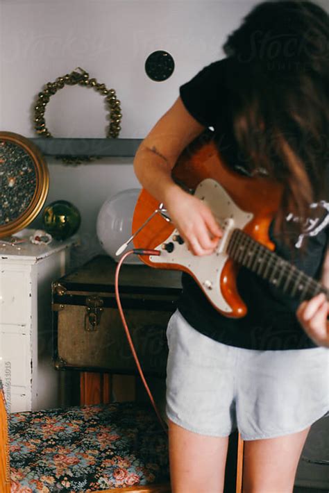 Young Brunette Woman Plays Guitar Indoors By Treasures And Travels