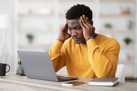 Stressed African American Manager Working On Laptop Touching Head