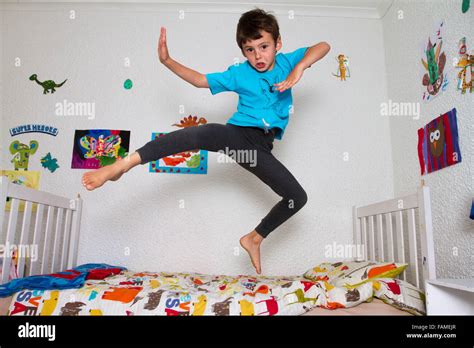 Boy Jumping On Bed Stock Photo Alamy