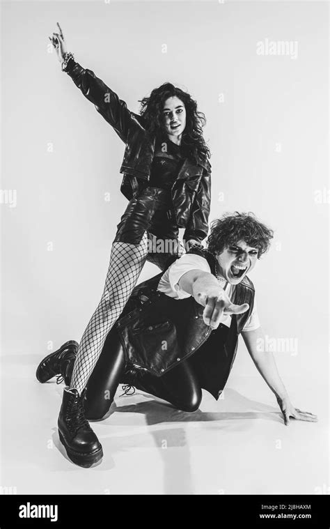 Monochrome Portrait Of Crazy Musicians Young Couple Wearing Black Leather Outfits Gesturing
