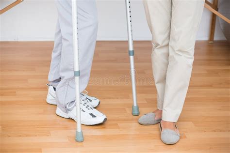 Doctor Helping Her Patient Walking With Crutch Stock Image Image Of