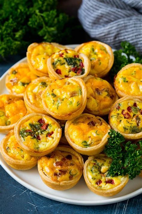 A Plate Of Mini Quiche Filled With Meats Vegetables And Cheeses
