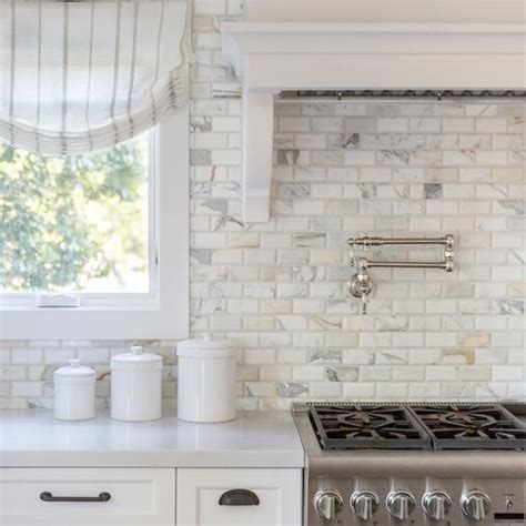 We're overhauling our kitchen and mudroom with lowe's. Calcutta gold marble beveled brick backsplash tiles in a ...