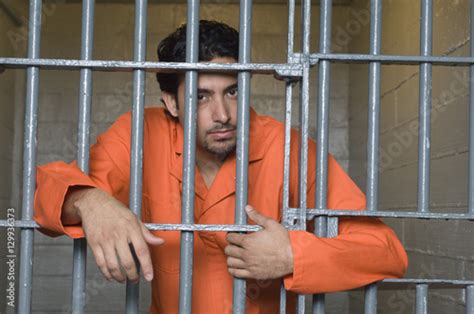 Portrait Of Prisoner Standing Behind Prison Bars Fotos De Archivo E