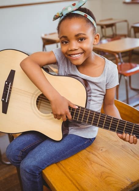 Premium Photo Little Girl Playing Guitar In Classroom