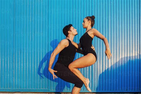 Professional Gymnast Couple Doing Balancing Pose By Blue Corrugated