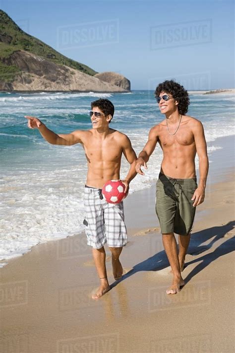 Teenage Boys Walking Along A Beach Stock Photo Dissolve