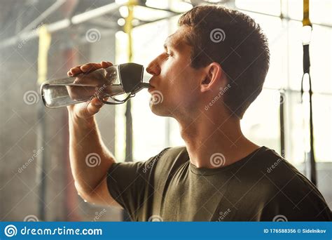 So Thirsty Young Athletic Man Drinking Water While Exercising At Gym