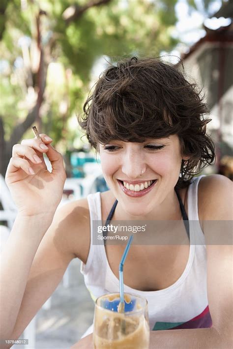 Smiling Woman Drinking Through Straw High Res Stock Photo Getty Images