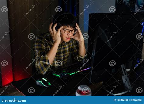 Asian Man Gamer In Headphones Stressed With Hand Feel Depressed Or
