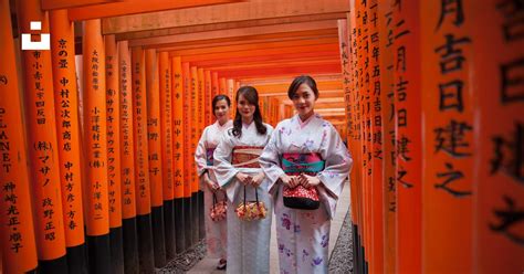 A Group Of Women Standing Next To Each Other In Front Of Orange Tori Tori Tori Photo Free