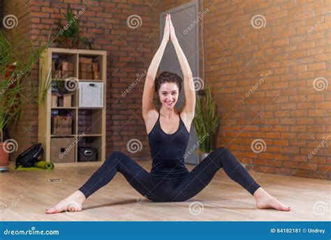 Portrait Of Beautiful Smiling Woman Doing Stretching Exercise Sitting On Floor With Her Legs