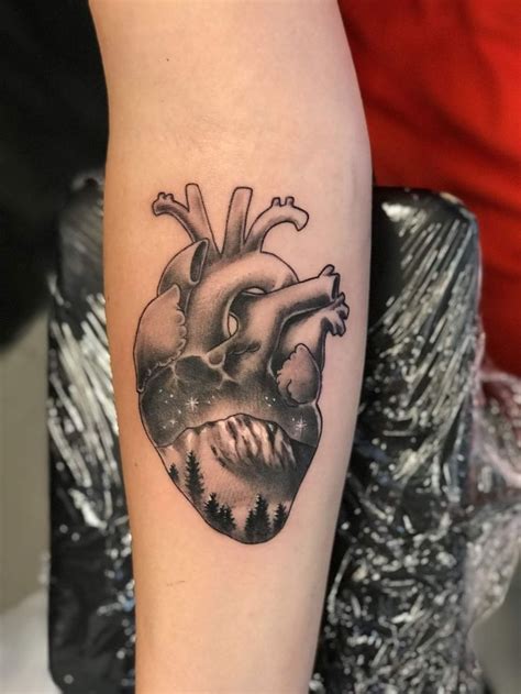 A Black And White Heart Tattoo On The Arm