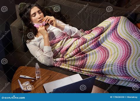 Young Woman On Sofa Covered With A Blanket Freezing Blowing Running Nose Got Fever Caught Sick