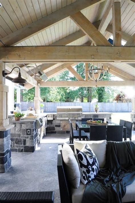 The storage area is mainly designed for your grill and additional this outdoor kitchen idea enables you to have a fully functional kitchen that can be used three seasons out of the year in cold climates, and. Covered patio features a rustic wood truss ceiling over an L shaped gray stone outdoor ...