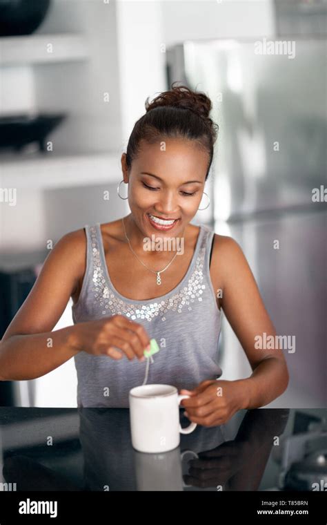 Happy Woman Holding A Cup Of Tea In Her Kitchen Stock Photo Alamy