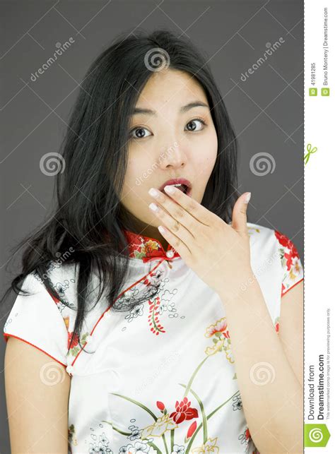 Shocked Asian Woman With Hand Over Mouth On Colored Background Stock