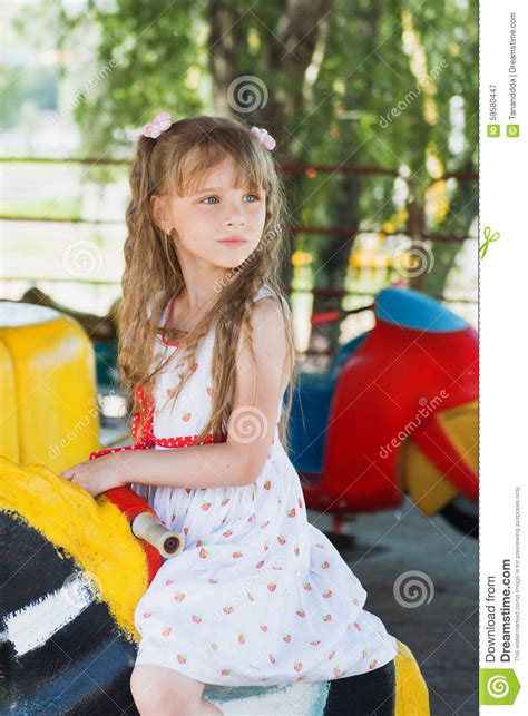 Cute Small Little Girl Riding A Colorful Carousel Stock