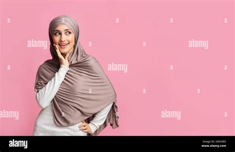 islamic fashion concept portrait of beautiful muslim girl in stylish hijab standing over pink