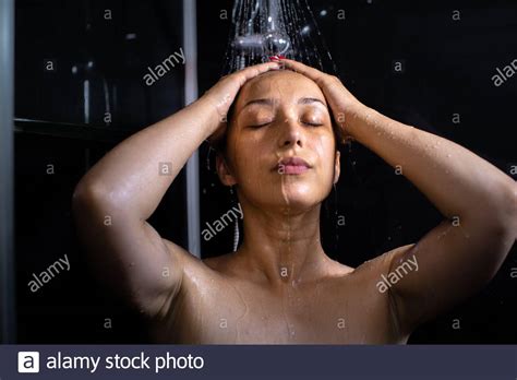 Woman Closes Her Eyes Letting Water Wash Over Her While Taking Shower