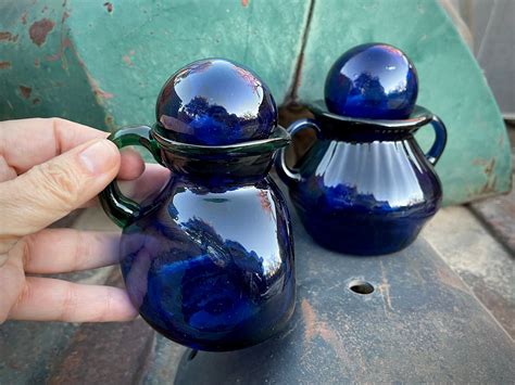 Pair Of Vintage Cobalt Blue Hand Blown Glass Bottles With Stoppers One With Green Glass Handle
