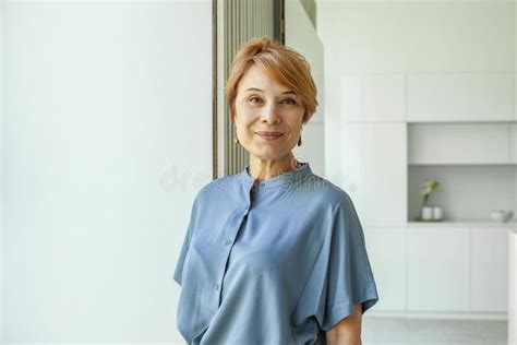 Close Up Portrait Of Beautiful Older Woman Smiling And Standing By Wall