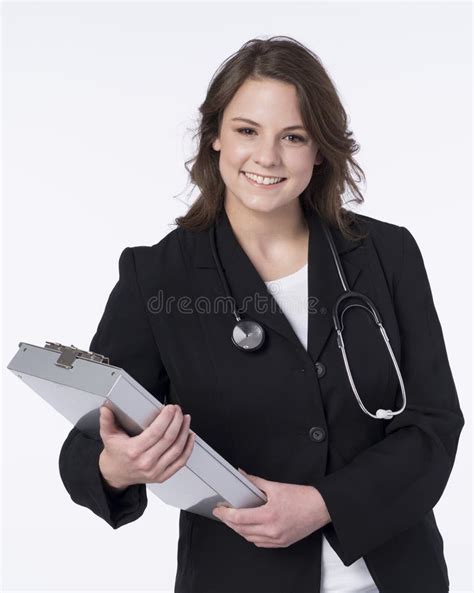 Female Doctor Standing And Smiling Holding Clipboard Stock Photo