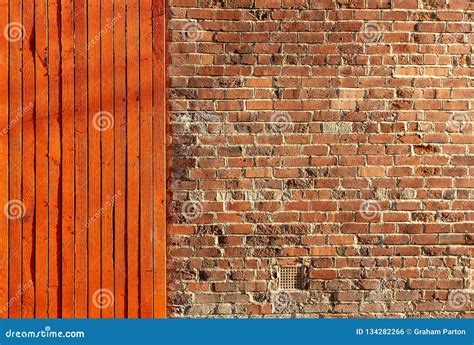 Bright Red Timber Fence Next To An Old Brick Wall Stock Photo Image
