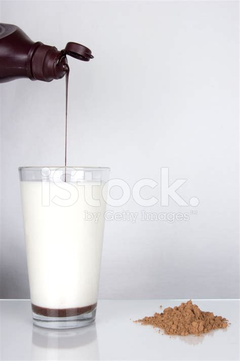 Chocolate Syrup Pouring Into Glass Of Milk Stock Photos