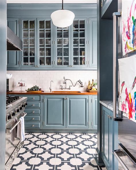 Kitchen tile flooring can be tricky to install for even seasoned diyers as the process requires a special saw for cutting pieces to fit around cabinets laundry room with geometric floors and white counters. Blue cabinets, gray and white tile floor in kitchen ...