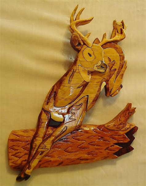 Deer Jumping Over A Log Sculpture By Russell Ellingsworth
