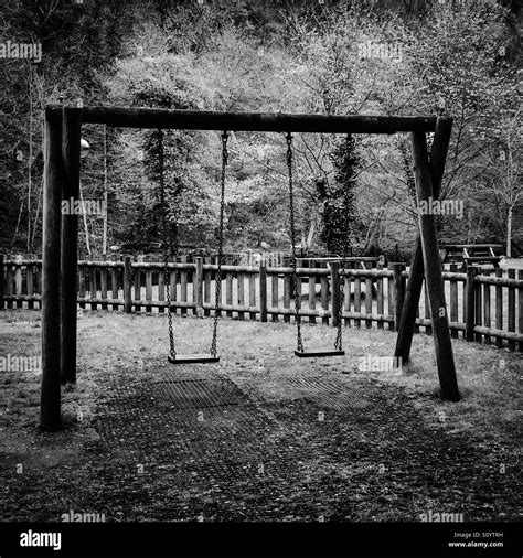 Black And White Photograph Of Swings In A Childrens Playground Stock