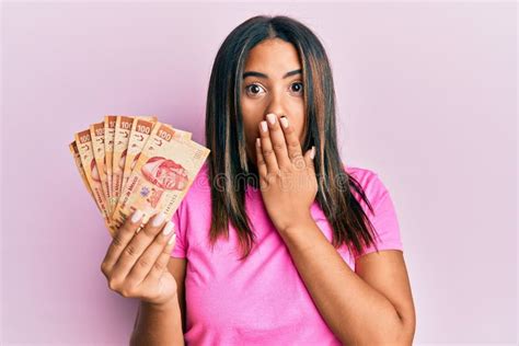 Young Latin Girl Holding Mexican Pesos Covering Mouth With Hand