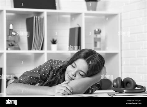 tired and bored teenager school girl schoolgirl is sleeping while doing homework tired from