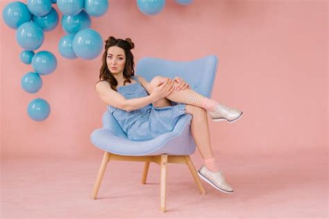 Girl In A Blue Dress In A Pink Room With A Blue Chair And Blue B Stock