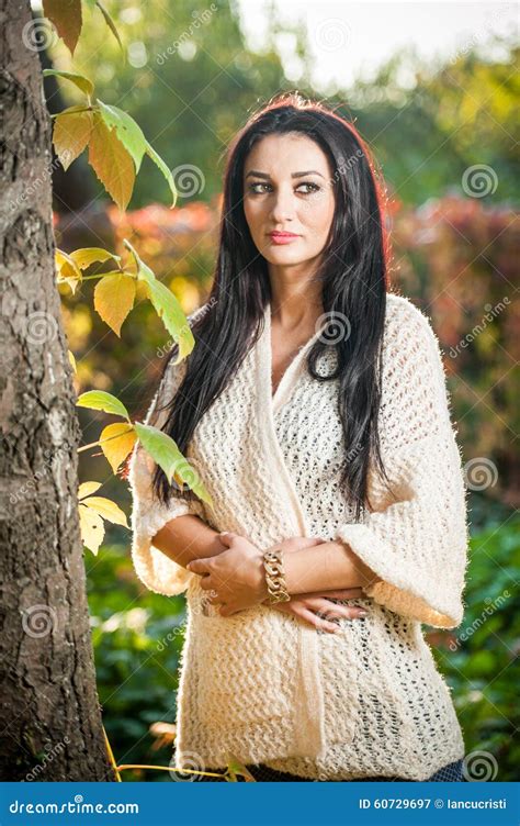 白色摆在的美丽的妇女在秋季公园 年轻深色的妇女在秋天的花费时间在一棵树附近在森林里 库存图片 图片 包括有 女孩 逗人喜爱