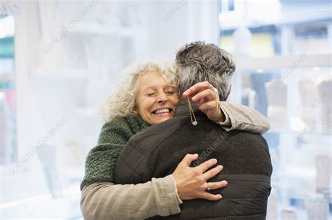 Smiling Senior Woman Hugging Husband In Jewelry Store Stock Image