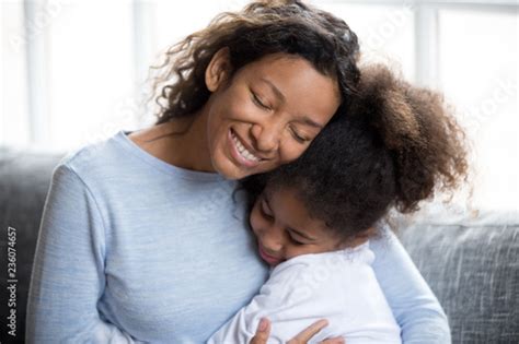 Loving African American Mother Embracing With Preschooler Little