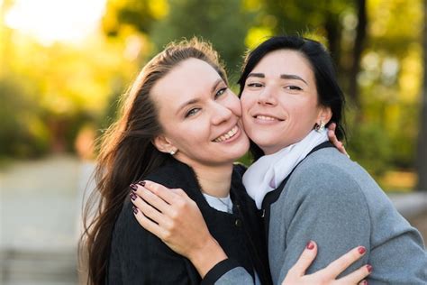 Dos Chicas Morenas Caucásicas Se Abrazan En El Soleado Parque De Otoño Feliz Pareja De