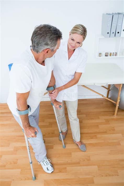 Doctor Helping Her Patient Walking With Crutch Stock Photo Image Of