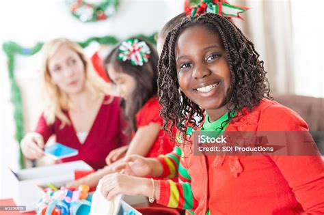 African American Girl Smiles Whilte Working On Christmas Charity