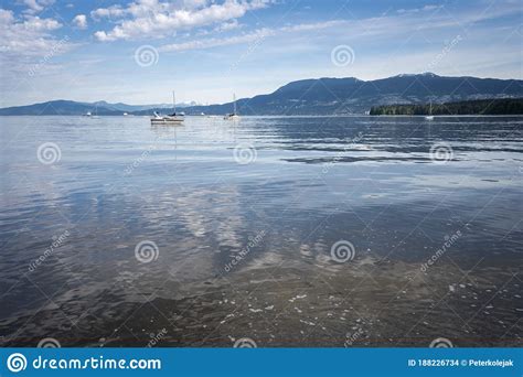 Calm Sea With Boats And Mountains In Backdrop Stock Photo Image Of