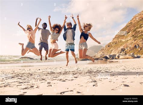 Group Of Friends Together On The Beach Having Fun Happy Young People Jumping On The Beach