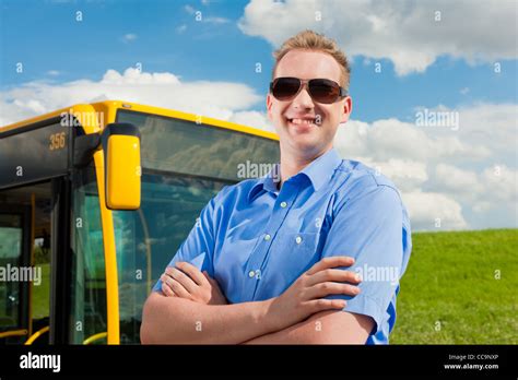Bus Driver Is Standing In Front Of His Bus Under Al Blue Sky Stock
