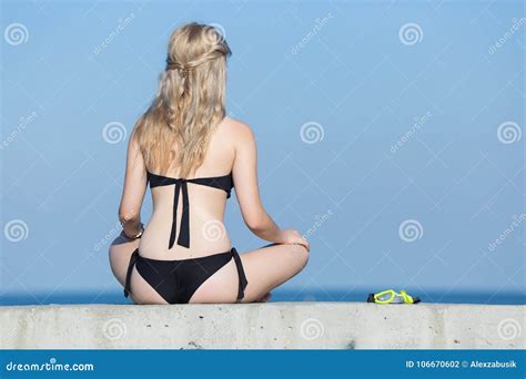 Ragazza In Bikini Nero Con Le Mani Sulle Ginocchia In Mare Fotografia