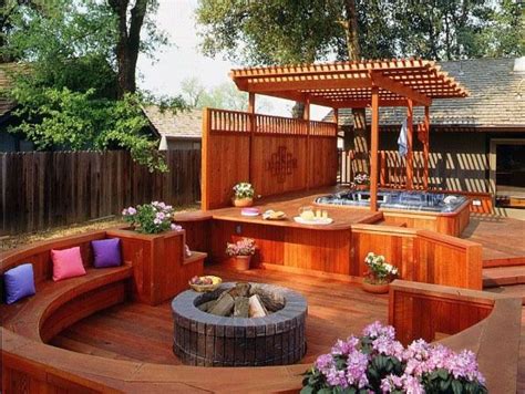 an outdoor hot tub and seating area on a deck in a backyard with wood