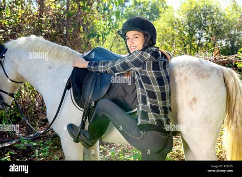 A Young Woman Rider Mounting A White Horse Stock Photo Alamy