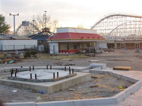 An Abandoned Amusement Park With Roller Coasters In The Background